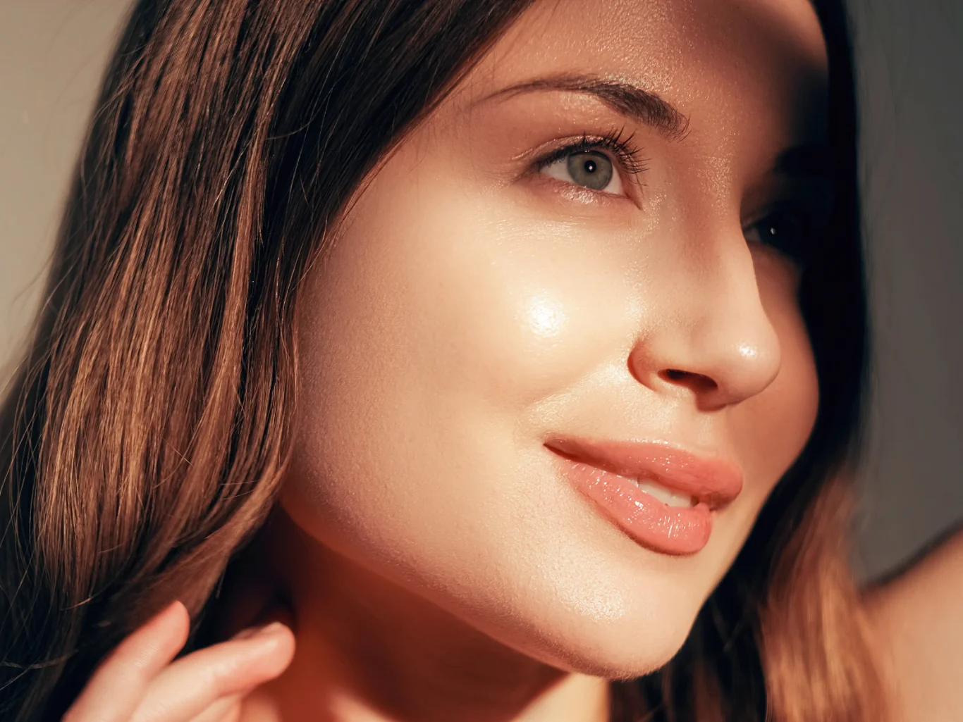 Close-up of a smiling woman with clear, glowing skin and an even complexion
